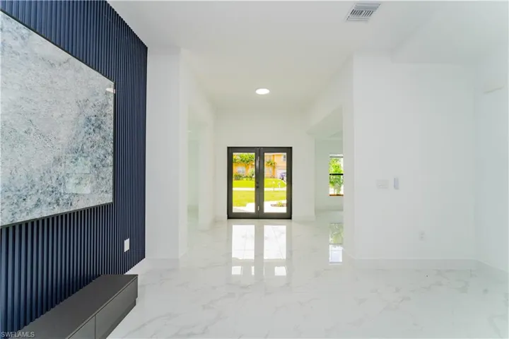 Hallway with light marble finish floors, french doors, recessed lighting, and wallpapered walls