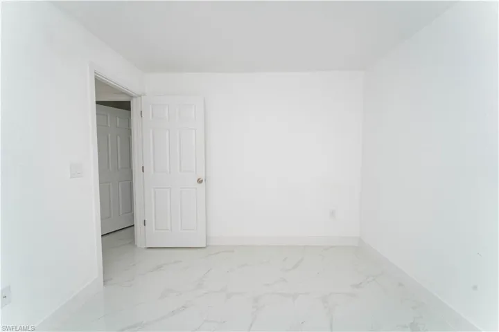Spare room featuring light marble finish floors