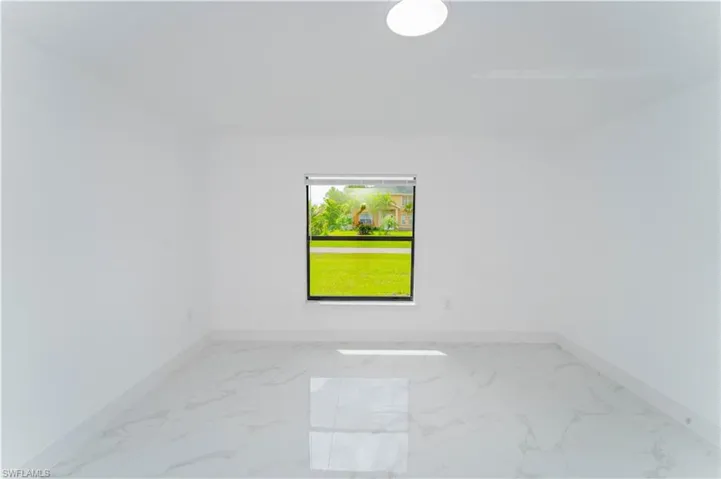 Unfurnished room featuring baseboards and light marble finish flooring