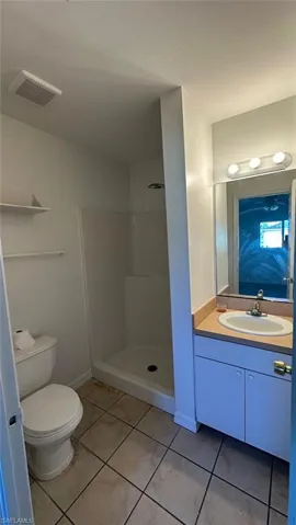 Bathroom featuring vanity, a shower stall, and light tile patterned flooring