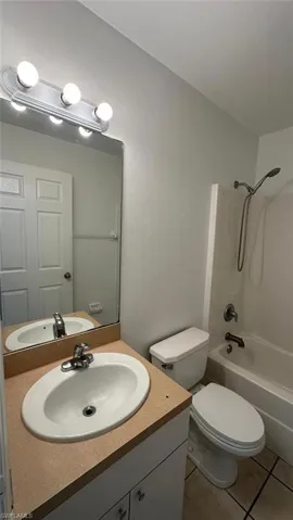 Full bath with  shower combination, vanity, and light tile patterned floors
