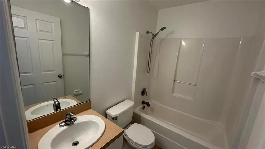 Bathroom featuring bathing tub / shower combination, light tile patterned floors, and vanity