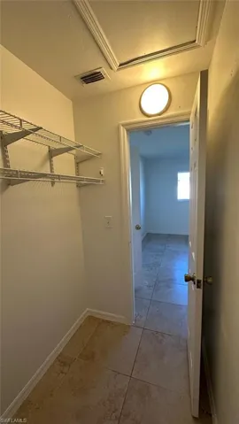 Garage featuring electric water heater, electric panel, washer and clothes dryer, and a garage door opener