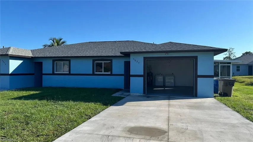 Ranch-style home with a front lawn, stucco siding, a shingled roof, and concrete driveway