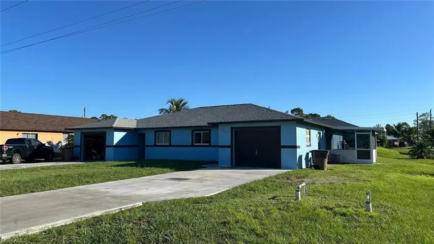 Ranch-style house featuring stucco siding, concrete driveway, an attached garage, a front yard, and a shingled roof