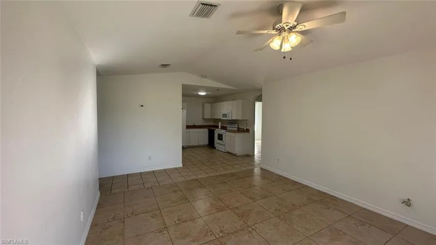 Hallway featuring light tile patterned floors and baseboards