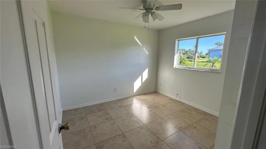 Unfurnished room with ceiling fan and light tile patterned floors