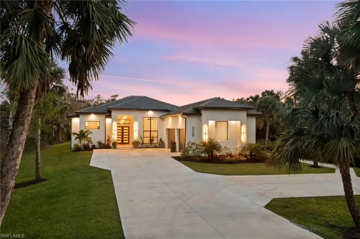 View of front of house with a yard and french doors