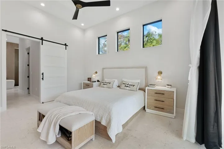 Bedroom with a barn door and ceiling fan