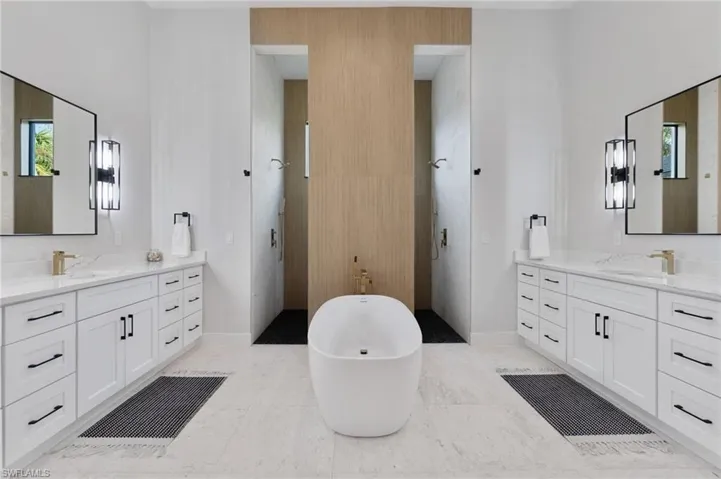 Bathroom featuring vanity and separate shower and tub