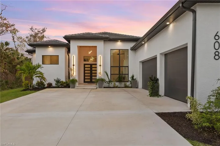 Exterior entry at dusk with a garage