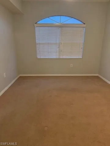 Empty room featuring light carpet and baseboards