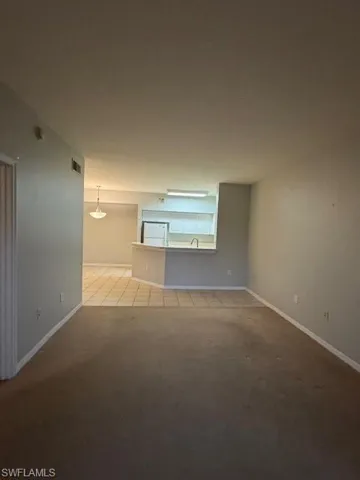 Unfurnished room featuring light colored carpet and light tile patterned floors