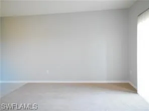 Empty room with baseboards and light carpet