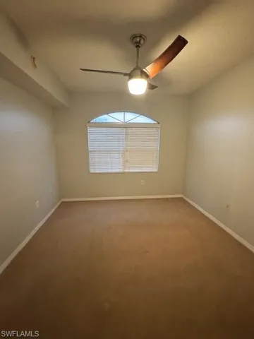 Spare room with carpet and a ceiling fan