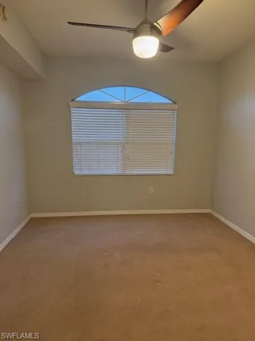 Unfurnished room with light colored carpet and a ceiling fan