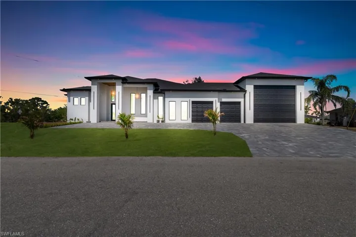 View of front of home featuring stucco siding, an attached garage, decorative driveway, and a lawn
