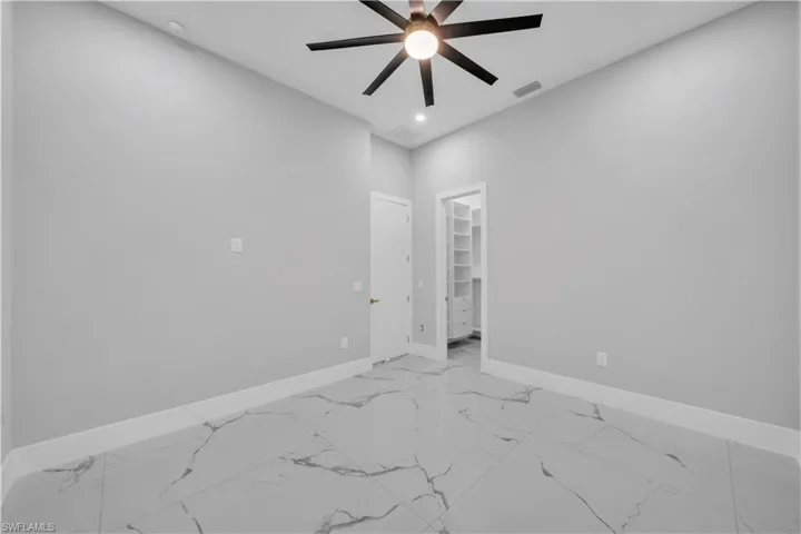 Unfurnished room with visible vents, baseboards, recessed lighting, a ceiling fan, and marble finish floor