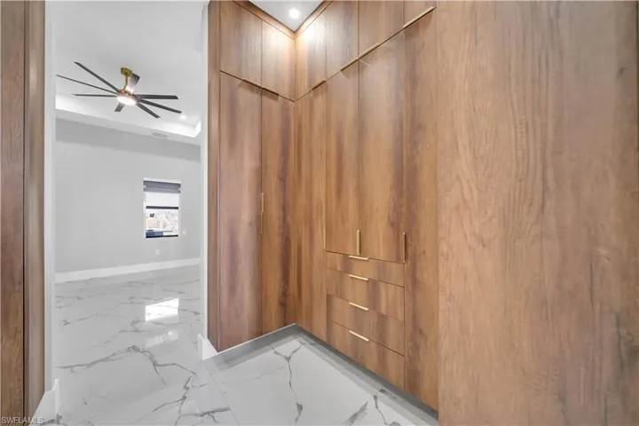 Hallway with recessed lighting, marble finish floor, and baseboards