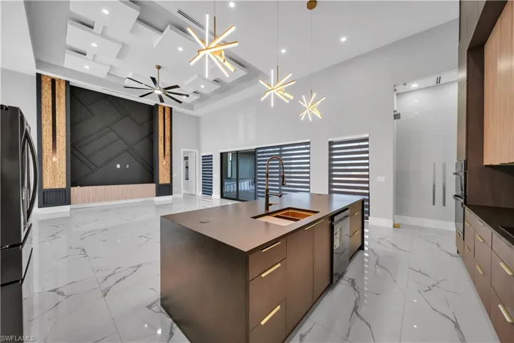 Kitchen featuring marble finish floor, baseboards, a sink, and modern cabinets