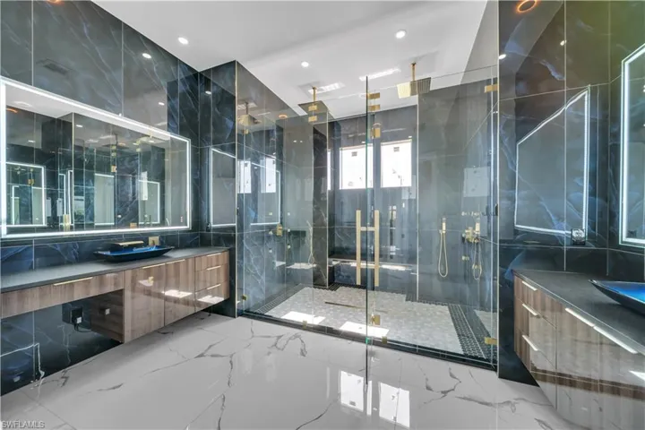 Bathroom featuring vanity, recessed lighting, marble finish floor, and a marble finish shower