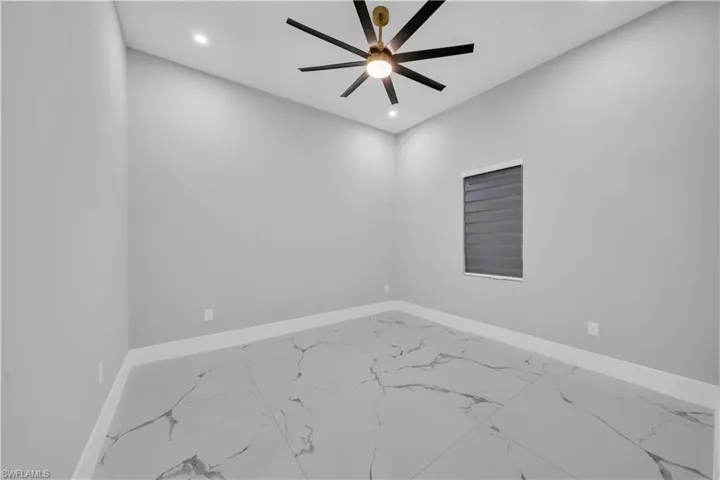 Spare room with baseboards, a ceiling fan, marble finish floor, and recessed lighting