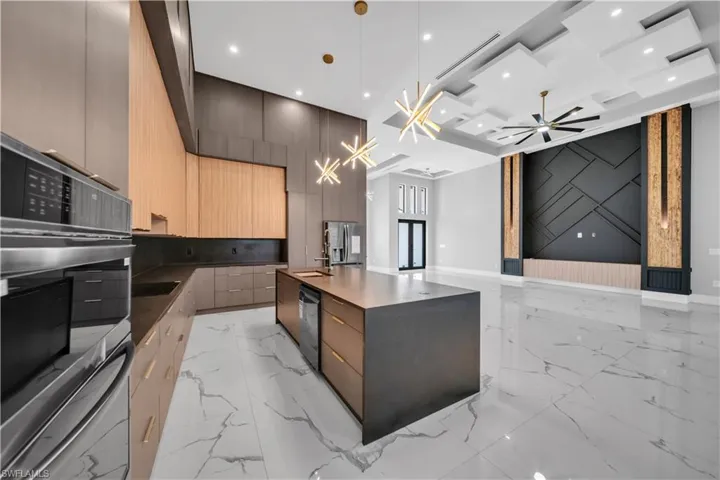 Kitchen with open floor plan, modern cabinets, marble finish floor, appliances with stainless steel finishes, and recessed lighting
