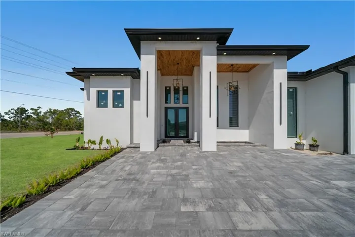 Property entrance with a lawn and stucco siding
