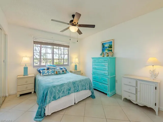 Tiled bedroom with a textured ceiling and ceiling fan