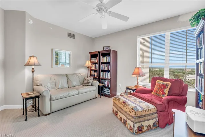 Carpeted living room with ceiling fan