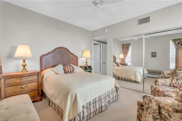 Bedroom with light colored carpet, a closet, and ceiling fan