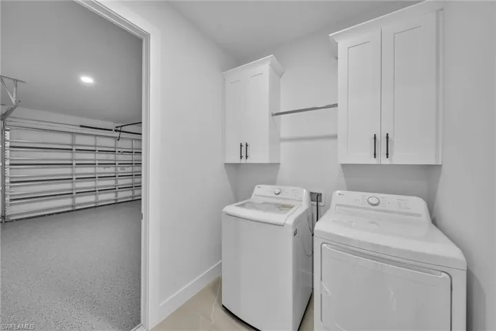 Clothes washing area featuring cabinets and independent washer and dryer