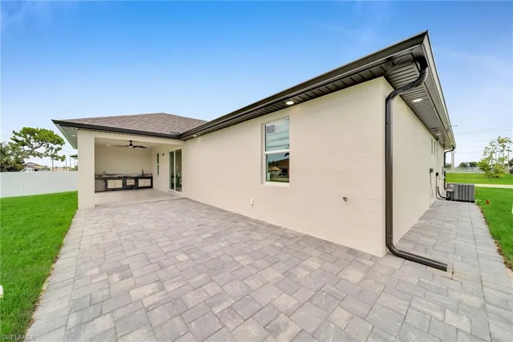 Rear view of house featuring ceiling fan, a yard, a patio area, and central AC