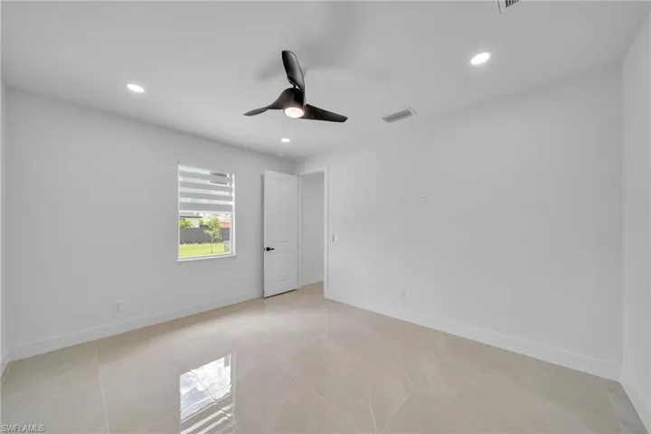 Spare room with ceiling fan and light tile patterned floors