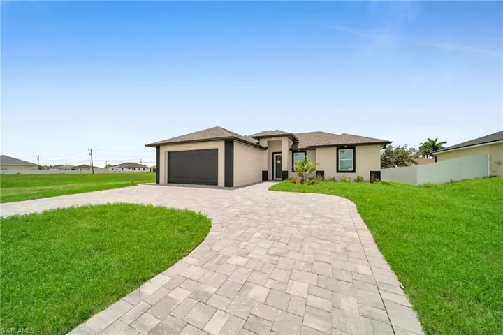 View of front of house featuring a garage and a front lawn
