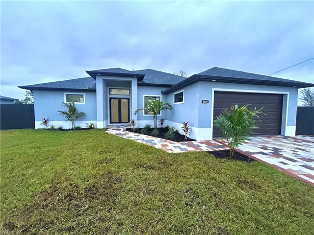 View of front of property with a front lawn and a garage