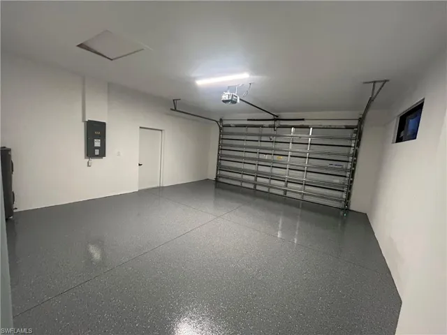 Garage featuring electric panel and a garage door opener