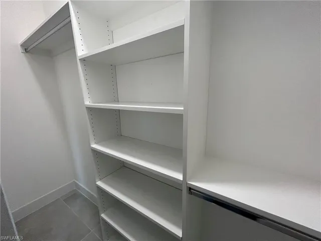 Walk in closet featuring dark tile patterned floors