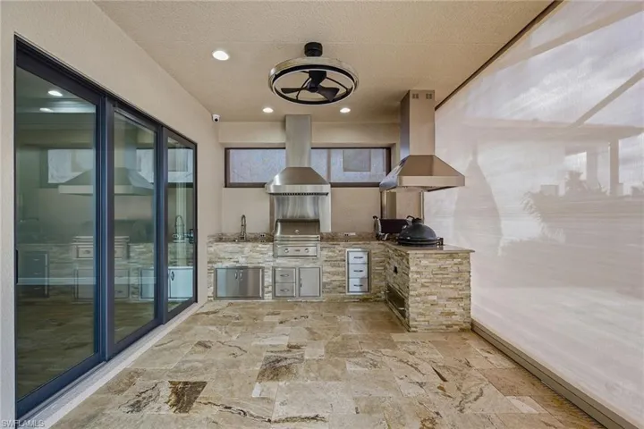 Outdoor Kitchen with gas Lynx grill, green egg and smoker. Wet sink and two hood vents