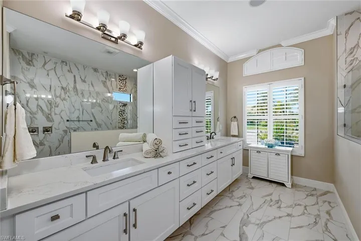 Dual sinks, marble tile, double shower head walk-in shower
