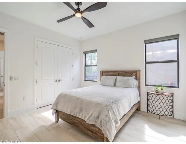 Bedroom featuring wood tiled floors, a ceiling fan, and a closet