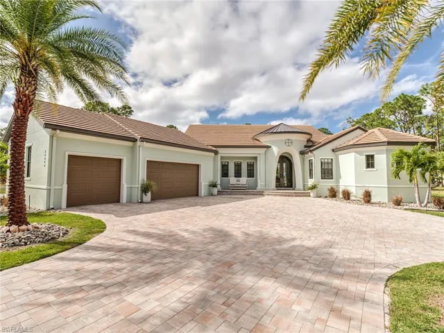 Mediterranean / spanish home with french doors, a garage, decorative driveway, stucco siding, and a tile roof
