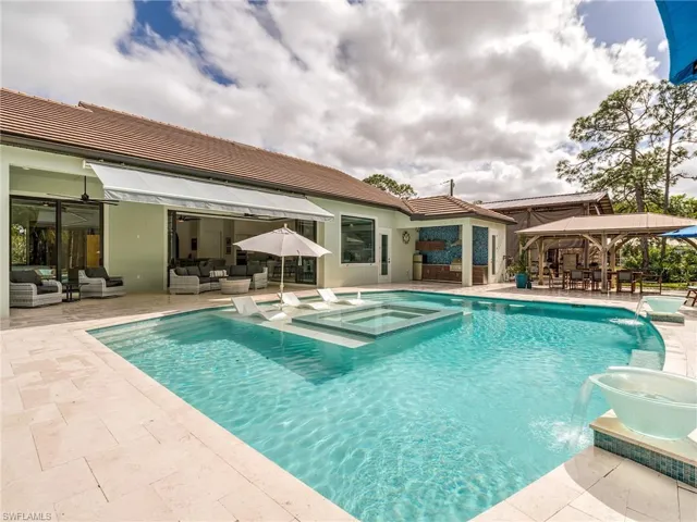 View of pool with an outdoor living space, a patio area, a gazebo, and a pool with connected hot tub