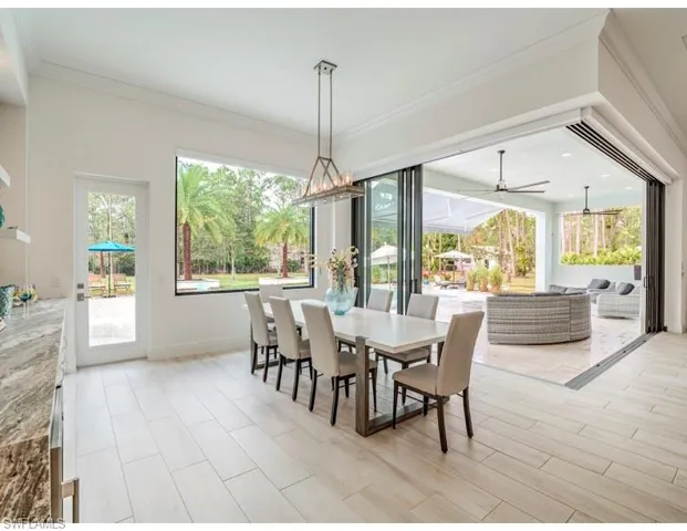 Dining room with ornamental molding, plenty of natural light, wood tiled floors, and a ceiling fan