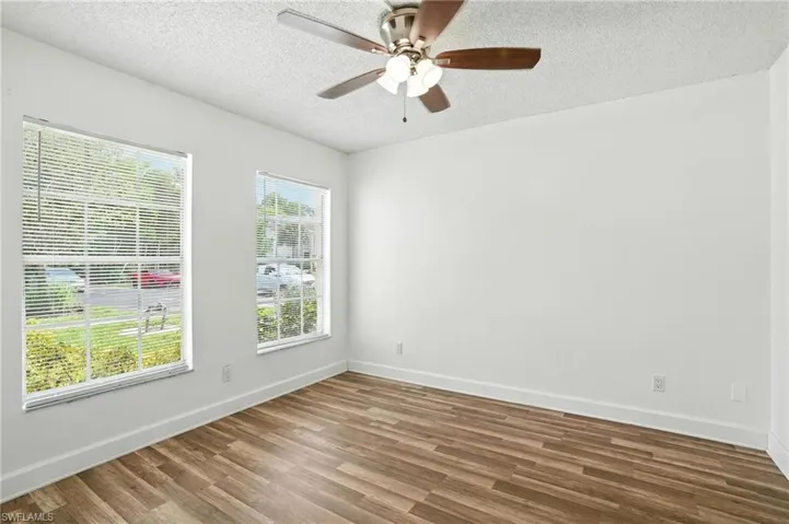 Empty room featuring wood finished floors, a textured ceiling, and ceiling fan