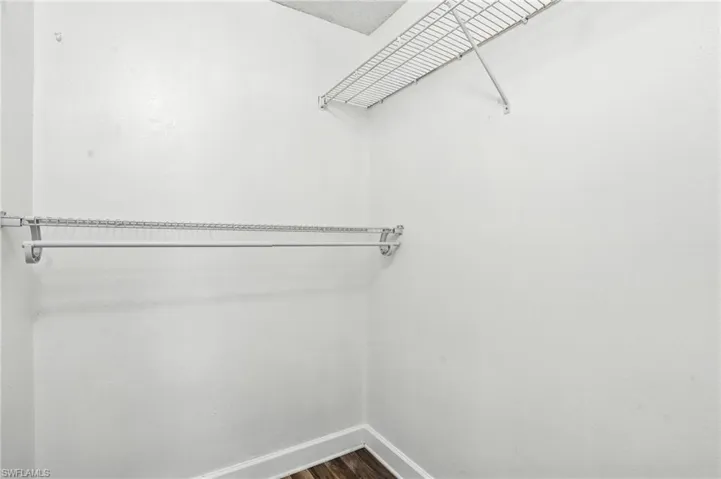 Spacious closet with dark wood-style floors