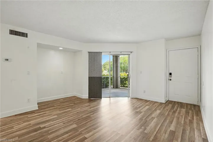 Unfurnished room featuring wood finished floors and a textured ceiling