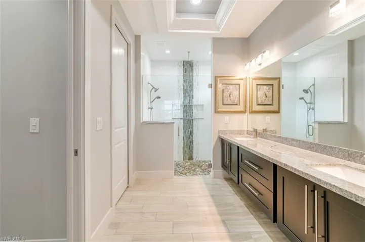 Bathroom featuring a custom vanity, with large  shower with glass enclosure