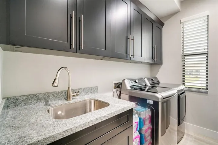 Laundry room with cabinets, sink, and washer and dryer