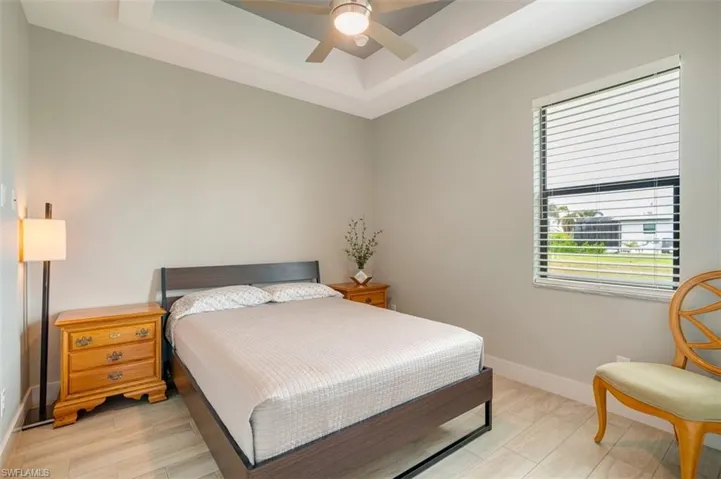 Bedroom with ceiling fan, a tray ceiling.